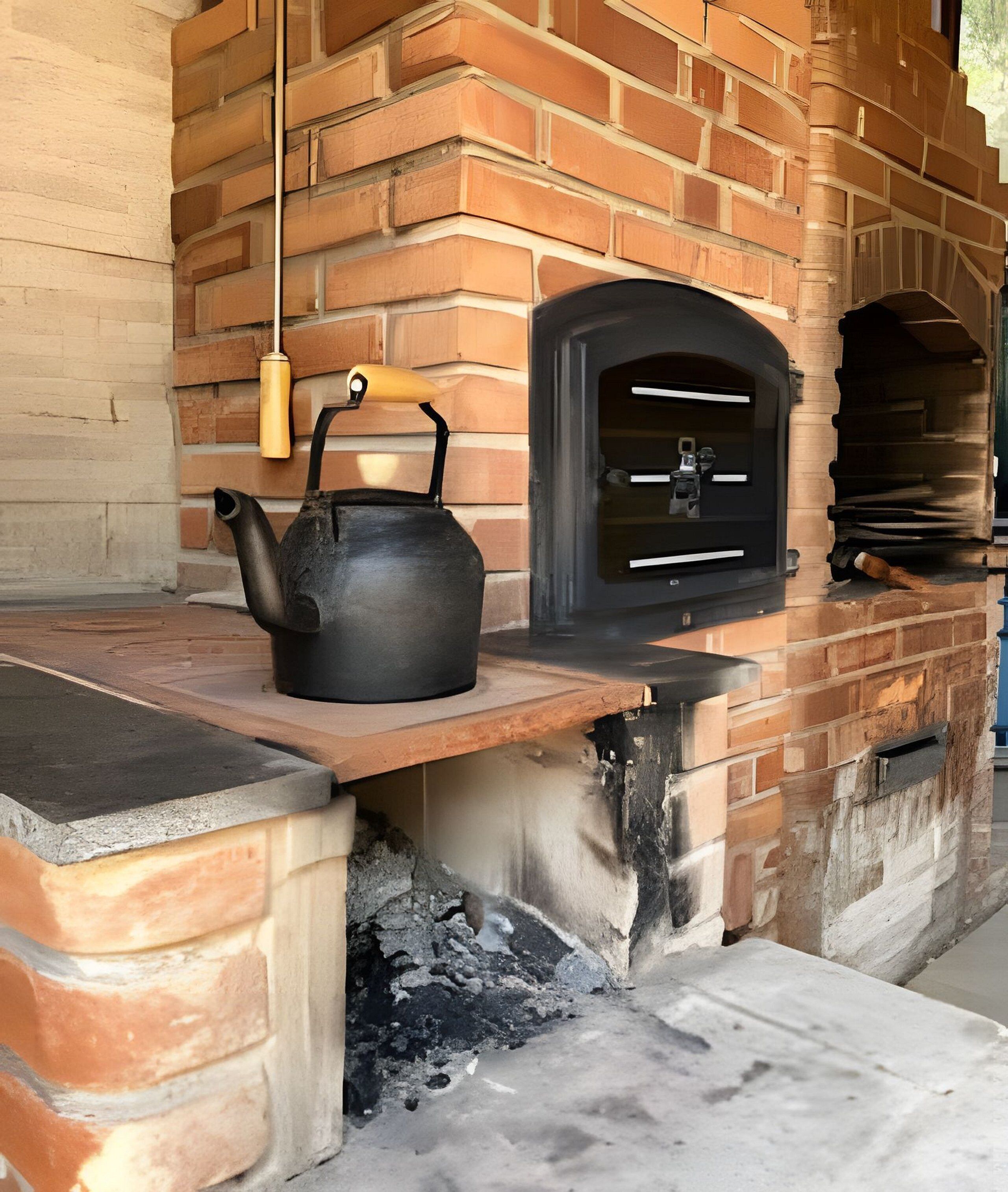 A brick oven with a kettle on a shelf, a hanging light fixture, and a window.