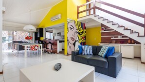 Una sala de estar moderna con un sofá, una mesa de centro y un mural llamativo.