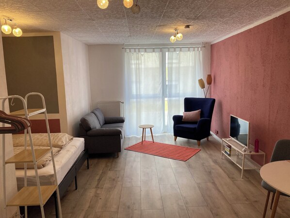 Un salon moderne avec un canapé, un fauteuil et un meuble pour la télévision.