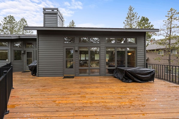 Una casa moderna con terraza, ventanas amplias y una chimenea.