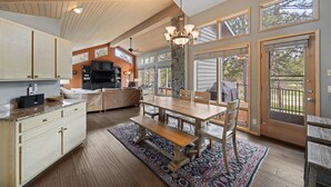 A spacious kitchen with a large island, wooden cabinets, and a stone accent wall. - TITL08 - Fantastic Sunriver Home, Hot Tub (Sunriver)