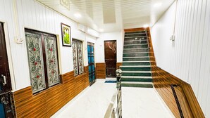 Una escalera con barandilla de madera y peldaños de mármol que conduce a una plataforma.