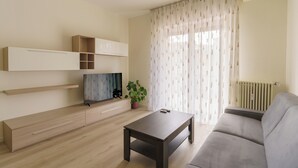 Ein modernes Wohnzimmer mit einer Couch, einem Couchtisch, einem Fernseher und integrierten Regalen.