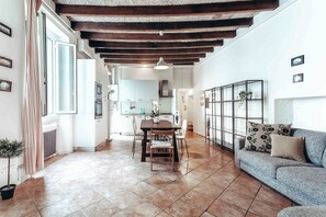 A spacious living area with a dining table, sofa, and kitchen in the background. - Stunning Flat near the Duomo (Milan)