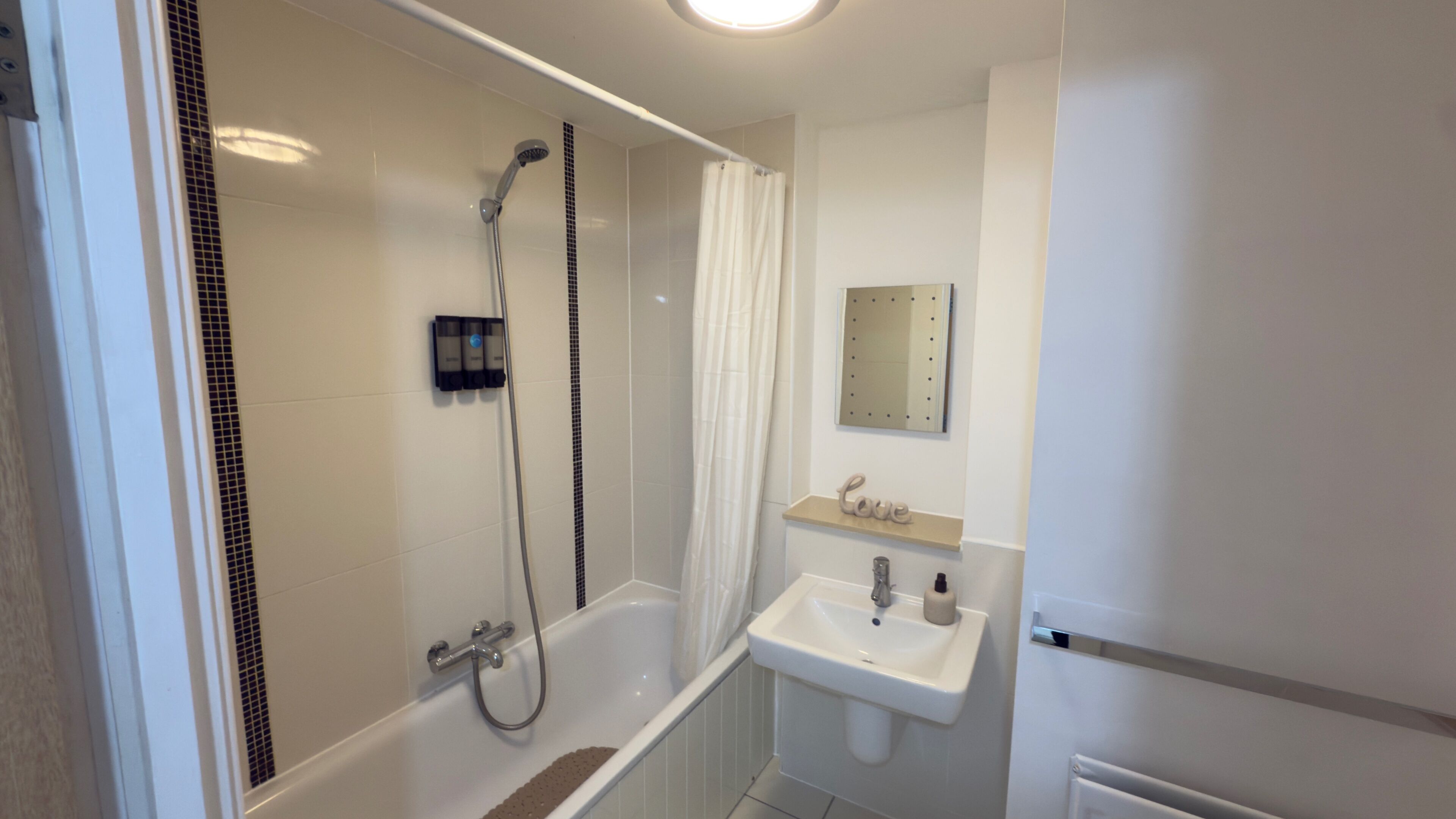 A modern bathroom with a shower, a bathtub, and a sink.