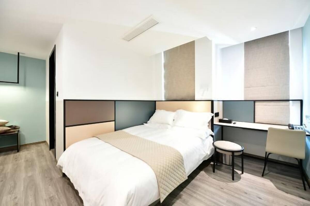 Una habitación de hotel moderna con una cama, un escritorio y una silla.