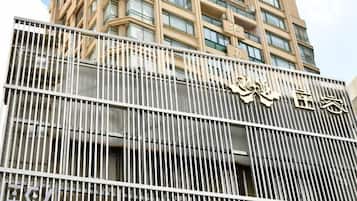 A modern building with a metal fence and a sign with Chinese characters.