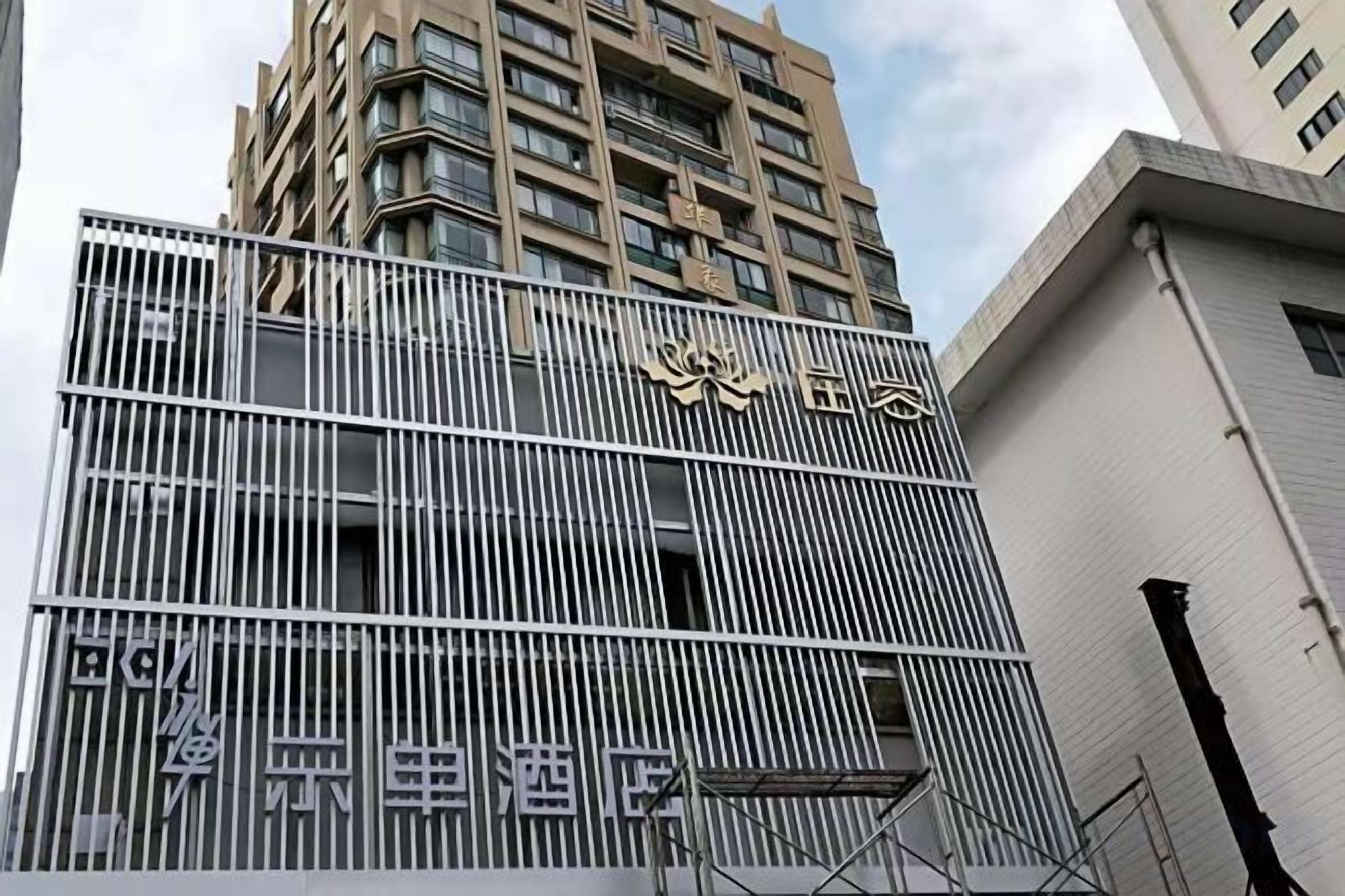 A building with a metal fence and a sign with Chinese characters.