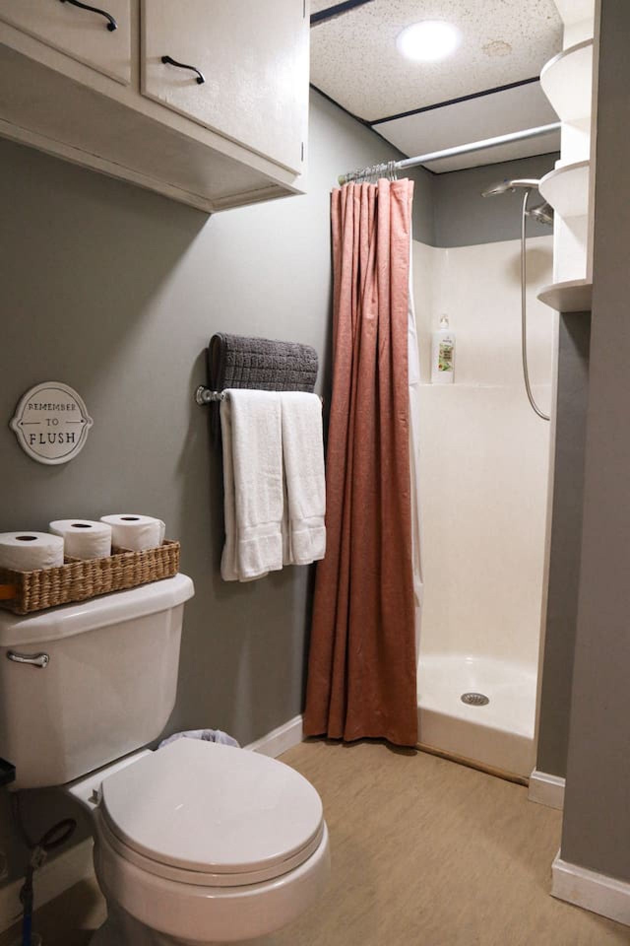 A bathroom with a toilet, a shower, and a towel rack.