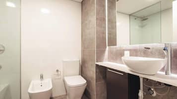 Un baño moderno con bidé, inodoro y un lavabo de diseño.