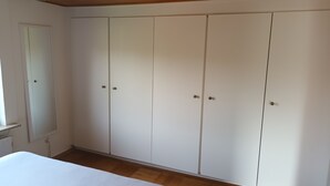 Un dormitorio con cama, armario y puerta.