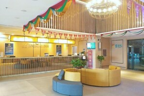 A hotel reception area with a counter, seating, and a chandelier. - Jinjiang Hotel (Beijing Shunyi Li Xiang Auto Base) (Beijing)