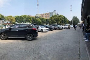 A street with parked cars and a building in the background. - Jinjiang Hotel (Beijing Shunyi Li Xiang Auto Base) (Beijing)