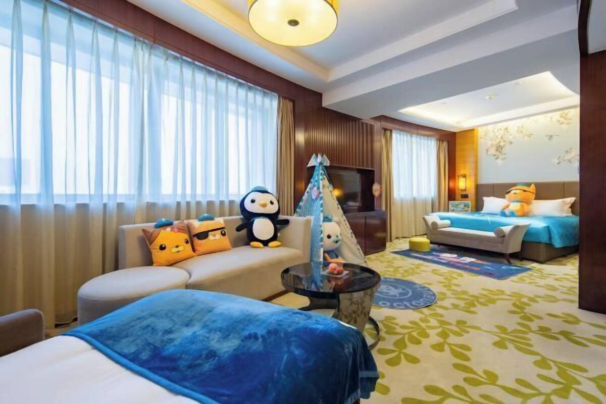 Ein Hotelzimmer mit einer Couch, einem Bett, einem kleinen Tisch und einer zeltartigen Konstruktion.