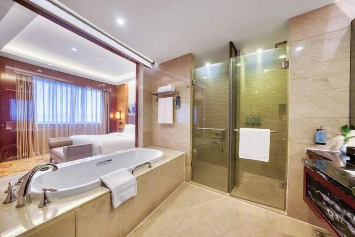 Ein modernes Badezimmer mit einer großzügigen Badewanne, einer Duschkabine aus Glas und einem Waschtisch mit Spiegel.