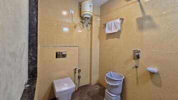 A bathroom with a toilet, bidet, and a shower.