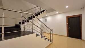 A modern interior with a staircase, a door, and a light fixture. - Aghor Guest House (Dharamshala)