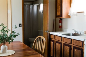 Une cuisine de taille réduite, avec des meubles de rangement en bois, un évier et un petit plan de travail.
