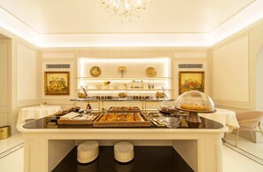 A buffet setup with various food items, a chandelier, and artwork on the walls. - Residenza d'epoca Luca Pacioli (Sansepolcro)