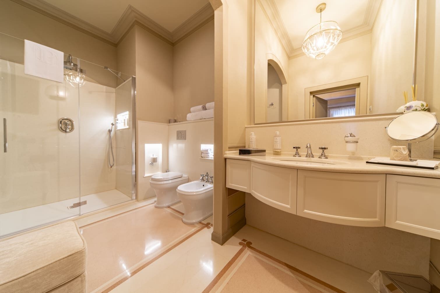 A modern bathroom with a glass-enclosed shower, a double sink vanity, and a large mirror.