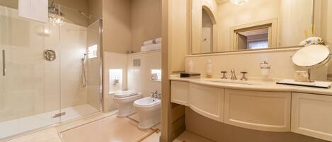 A modern bathroom with a glass-enclosed shower, a double sink vanity, and a large mirror.