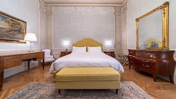 Un dormitorio amplio con una cama grande, un aparador de madera, un escritorio y una silla.