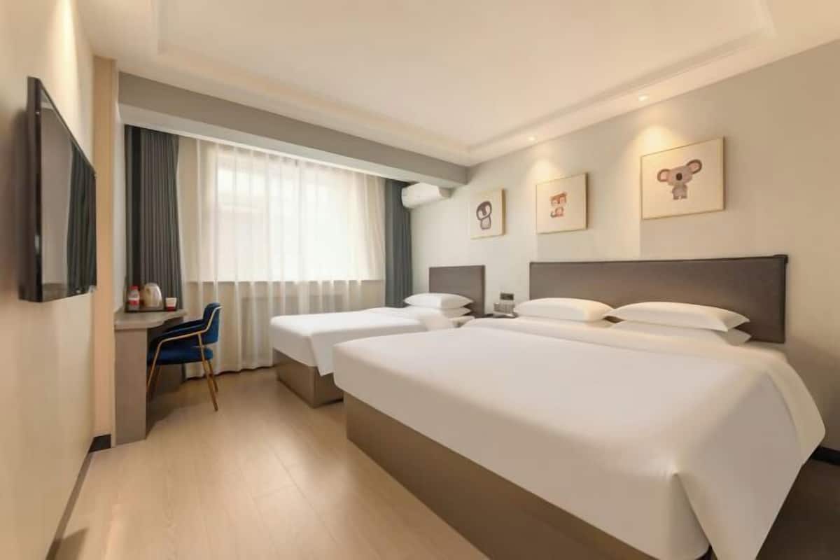 Een hotelkamer met twee bedden, een bureau en een stoel.