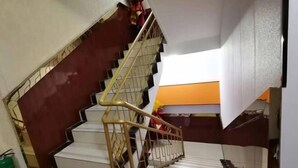 A staircase with a handrail and a red wall. - Tuyou Shuxiang Homestay (Lanzhou)