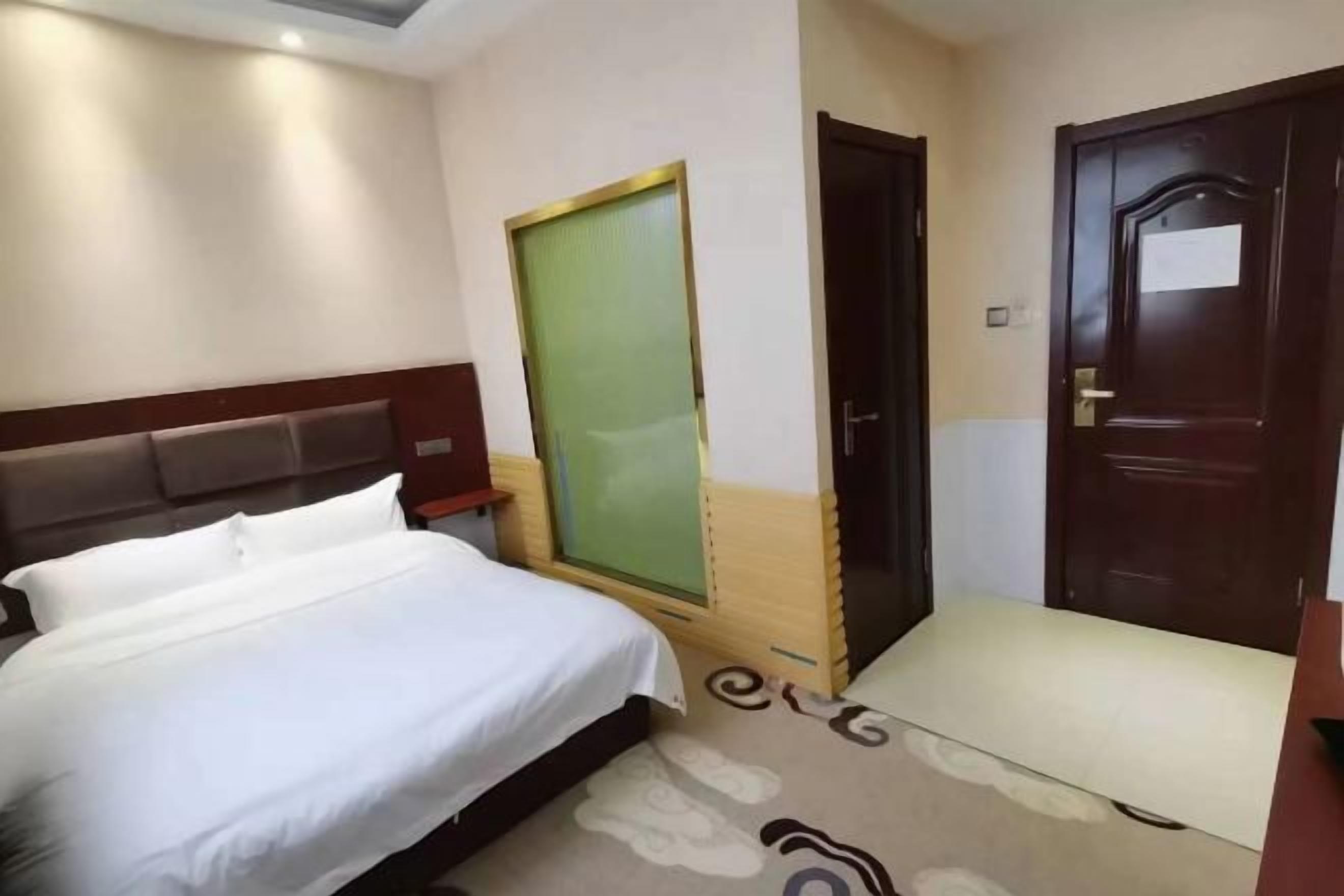 Una habitación de hotel con cama, escritorio, silla y puerta.