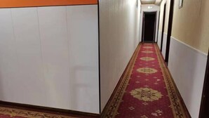 A hallway with a red carpet and white walls. - Tuyou Shuxiang Homestay (Lanzhou)