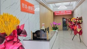 A hotel reception area with a marble floor, a reception desk with a cash register, and a sign indicating a new installation. - Tuyou Shuxiang Homestay (Lanzhou)