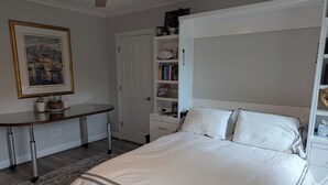 A bedroom with a bed, a desk, and a bookshelf. - Charming studio in lovely Charlotte with WiFi, AC (Charlotte)