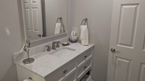 A bathroom with a double sink, a large mirror, a towel rack, and a toilet. - Charming studio in lovely Charlotte with WiFi, AC (Charlotte)