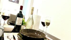 A dining table with wine glasses, a bottle of wine, a decorative glass, and a bowl. - Luxury B&B Apartment in Parella - Near Turin Center - Métropolitain & Museum (Torino)