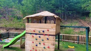 A wooden play structure with a climbing wall and a slide. - Tranquil apartment in Caprara with stunning views (Caprara)