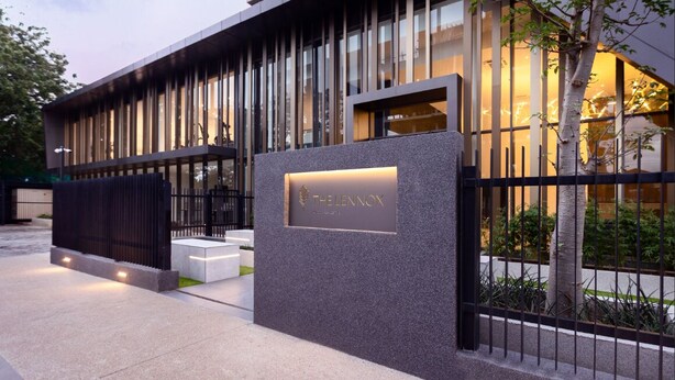 A modern building with a prominent entrance, a nameplate, and a well-lit facade. - Snug three-bedroom Unit (Accra)