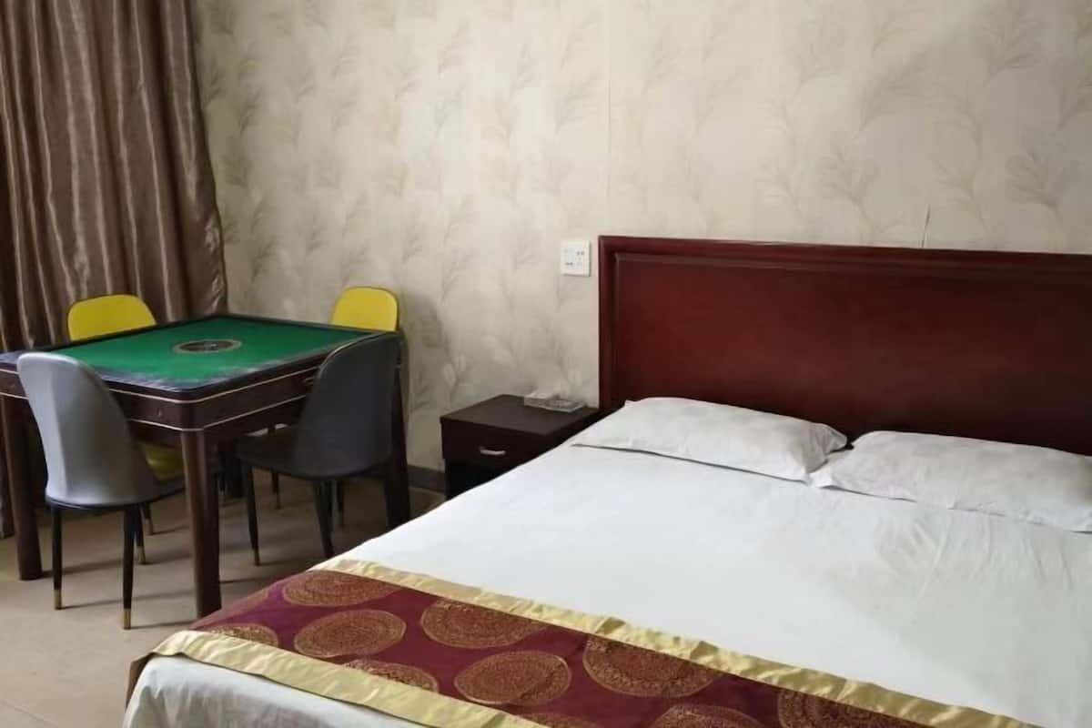 Una habitación de hotel con una cama, una mesa de billar verde y dos sillas.