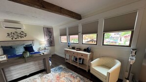 A cozy room with a bed, a desk, a chair, and a large rug.