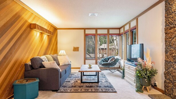 A living room with a sofa, coffee table, and a TV.