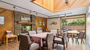 A cozy dining area with wooden furniture and a stone wall.