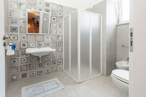 Een douche, een bidet, zeep, toiletpapier