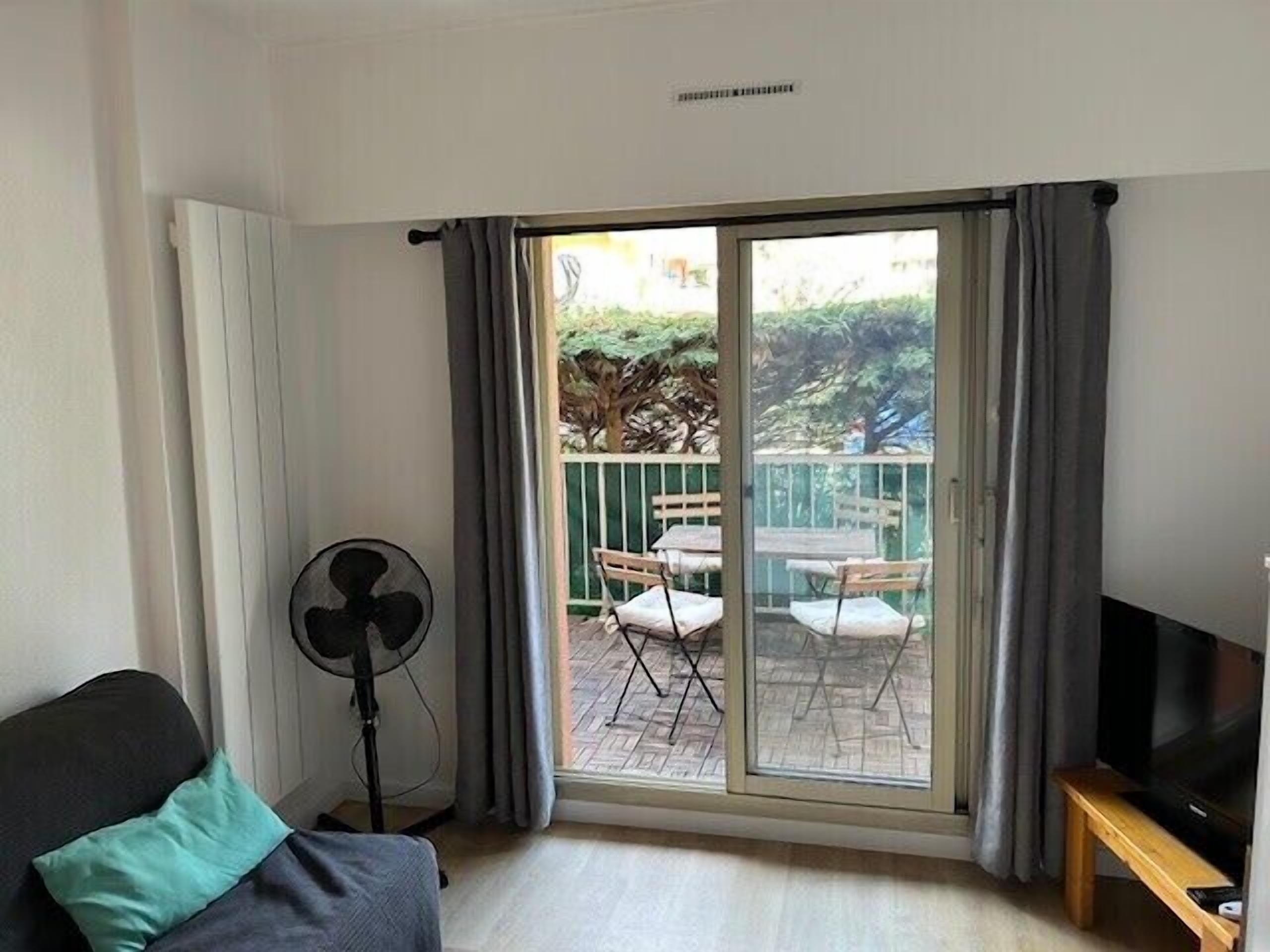 A room with a sliding glass door leading to an outdoor patio with a table and chairs.