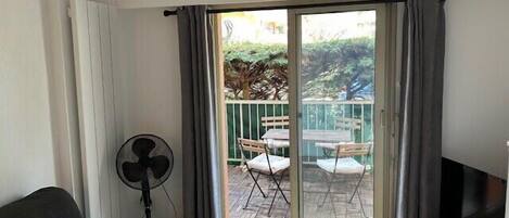 A room with a sliding glass door leading to an outdoor patio with a table and chairs.