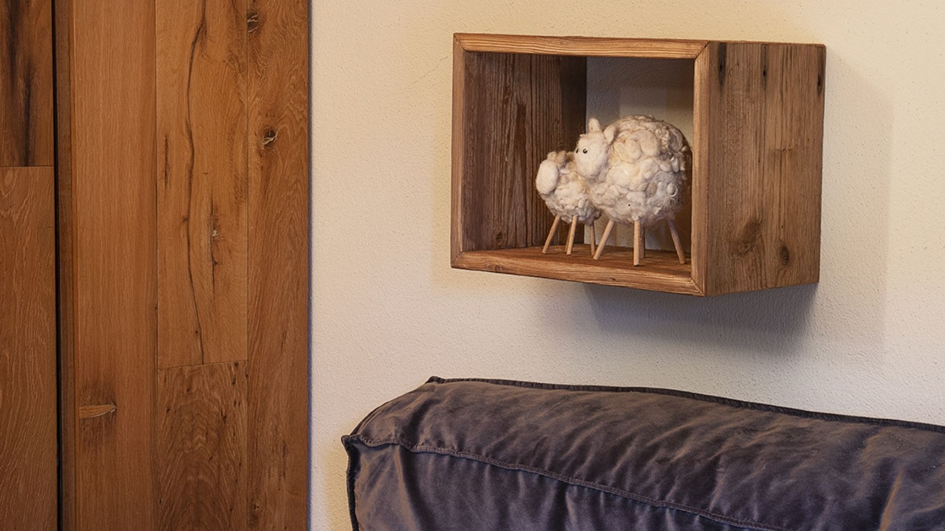 Un mueble de madera con una escultura de oveja lanuda.