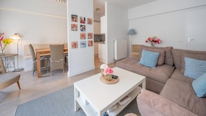 Un salon moderne avec un canapé, une table basse et un coin repas.