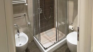 A modern bathroom with a glass-enclosed shower, a bidet, and a toilet. - rienzo vatican suites  (Rome)