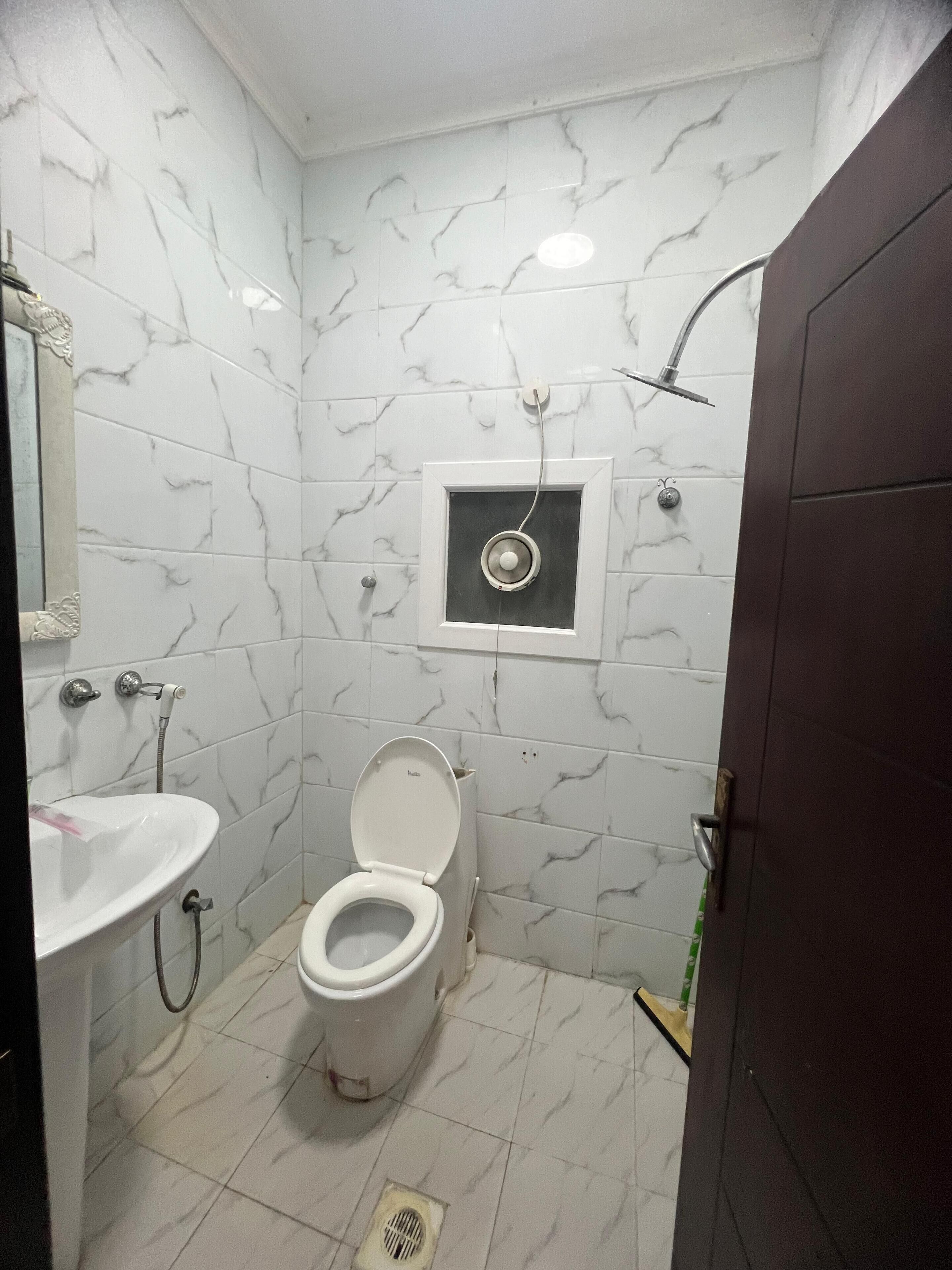 A bathroom with a toilet, sink, and shower.
