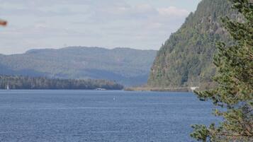 A calm lake with a forested mountain in the background.