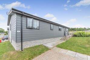 A single-story mobile home with a stone foundation, a front porch, and a small front yard. - 3 Bed in Broadwoodwidger (oc-s31783) (Broadwoodwidger)