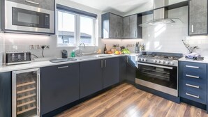Una cocina moderna con microondas integrado, electrodomésticos de acero inoxidable y un amplio ventanal que proporciona luz natural.